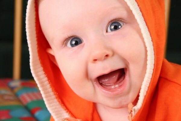 close up of happy little boy with orange hood