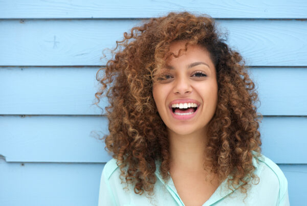 Cheerful young woman with curly hair smiling